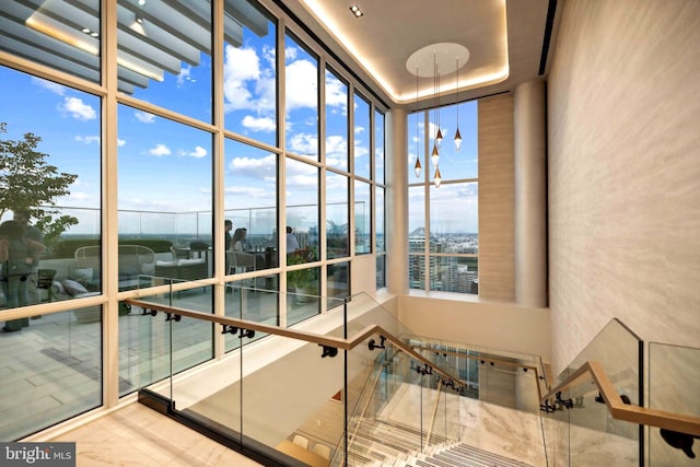 interior space featuring a high ceiling, a healthy amount of sunlight, and a wall of windows