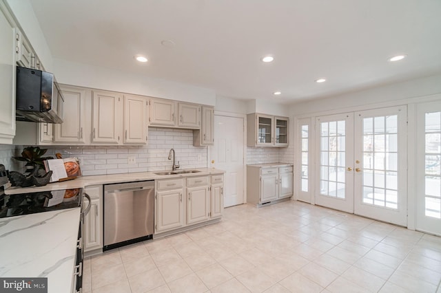 kitchen with dishwasher, sink, decorative backsplash, light stone counters, and french doors