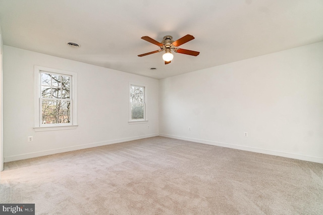 empty room featuring ceiling fan and light colored carpet