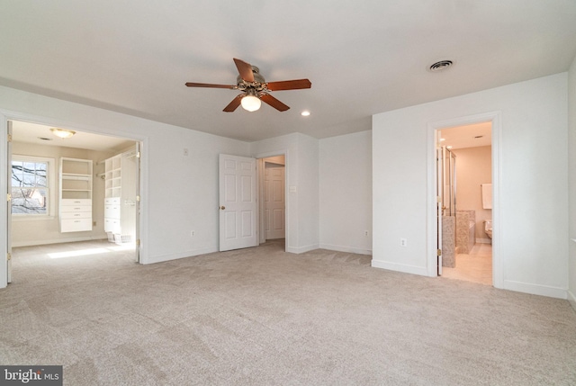 unfurnished bedroom with connected bathroom and light colored carpet