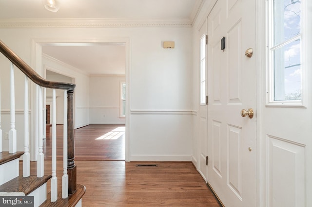 entryway featuring hardwood / wood-style floors, crown molding, and a healthy amount of sunlight