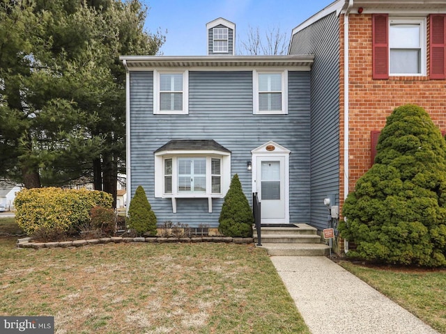 view of front of property featuring entry steps and a front yard