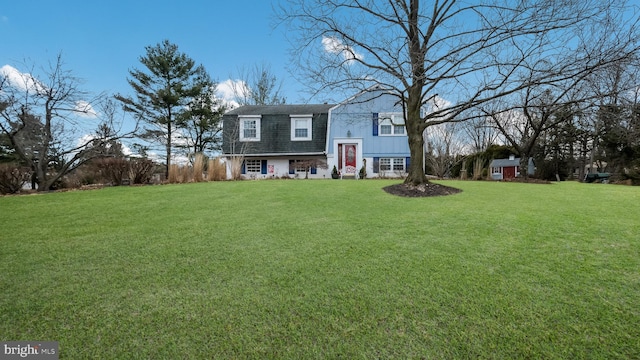 view of front of house featuring a shed and a front lawn