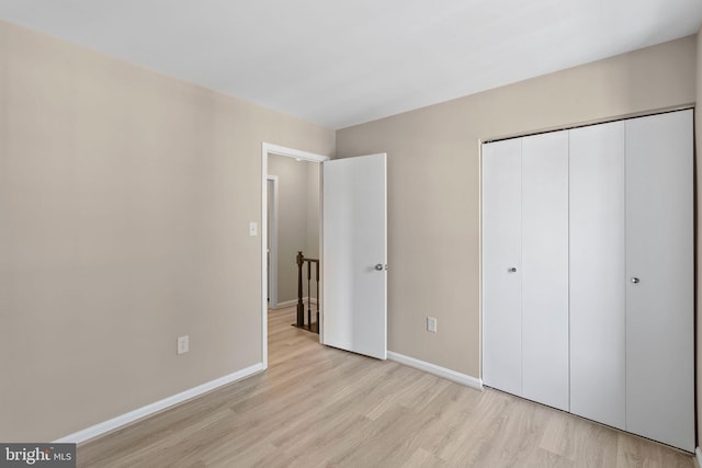 unfurnished bedroom featuring a closet and light hardwood / wood-style flooring