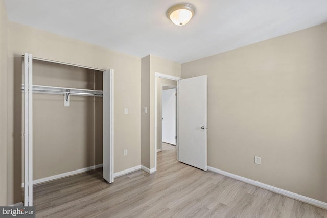 unfurnished bedroom with light hardwood / wood-style floors and a closet