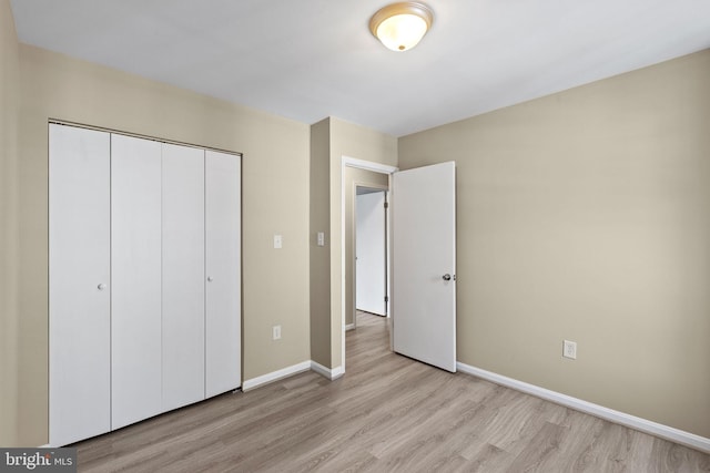 unfurnished bedroom featuring light hardwood / wood-style floors and a closet