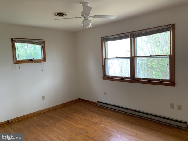 spare room with baseboard heating, ceiling fan, light hardwood / wood-style flooring, and a wealth of natural light