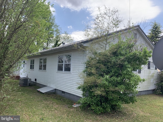 view of property exterior with central air condition unit and a lawn