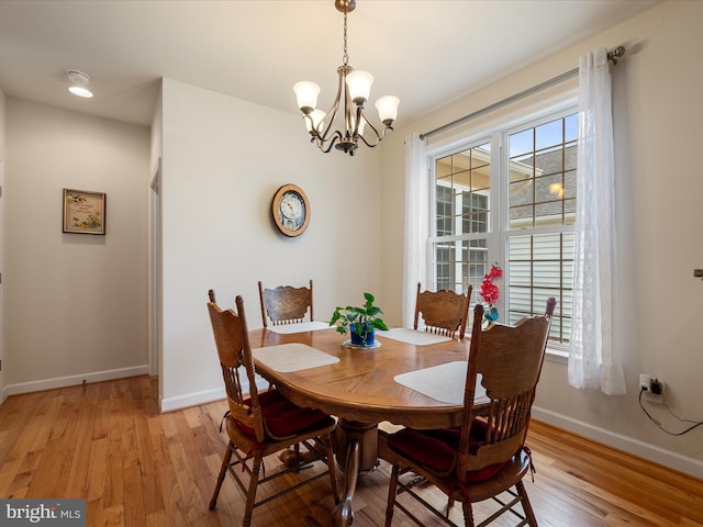 dining space with a notable chandelier and light wood-type flooring