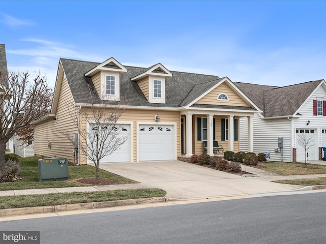 cape cod house featuring a garage and covered porch