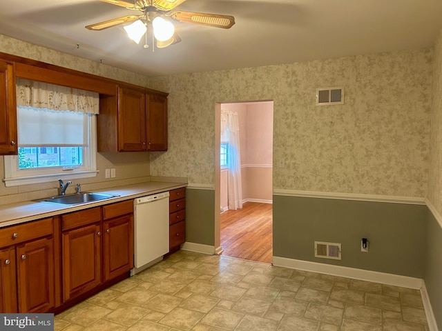 kitchen featuring ceiling fan, white dishwasher, and sink