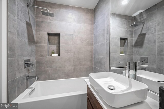 bathroom with vanity and tiled shower / bath