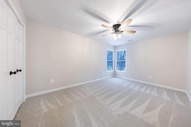 unfurnished bedroom with light colored carpet, ceiling fan, and a closet