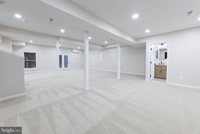 basement featuring sink and light carpet