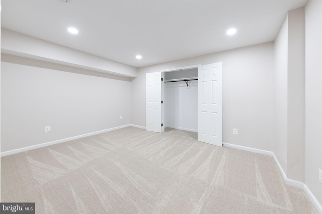 unfurnished bedroom featuring light colored carpet and a closet