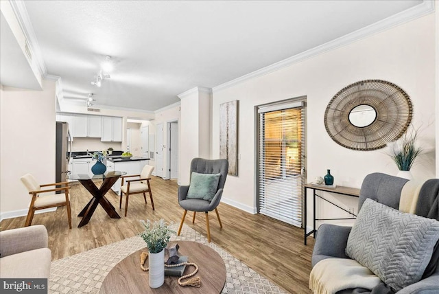 living room with ornamental molding and light hardwood / wood-style floors