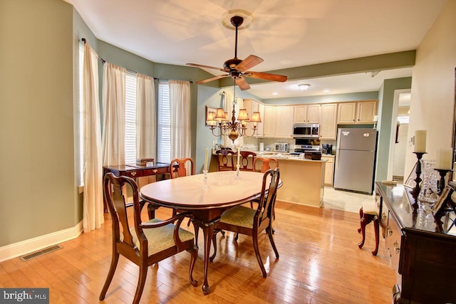 dining area featuring ceiling fan with notable chandelier and light wood-type flooring