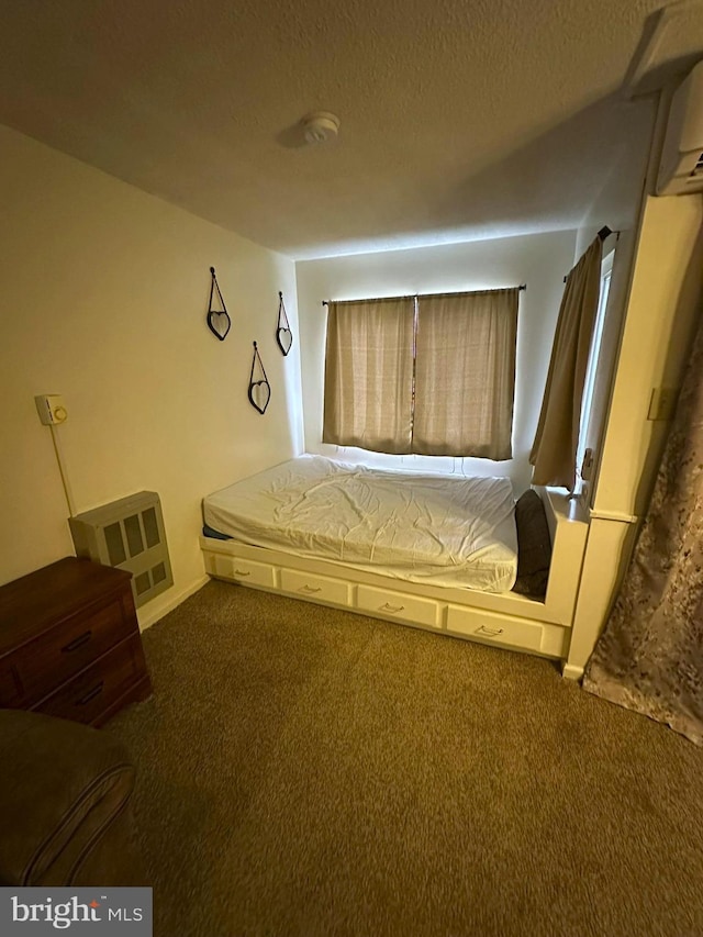 unfurnished bedroom with carpet flooring, a wall mounted AC, and a textured ceiling