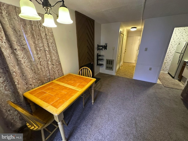 carpeted dining space with heating unit and a textured ceiling