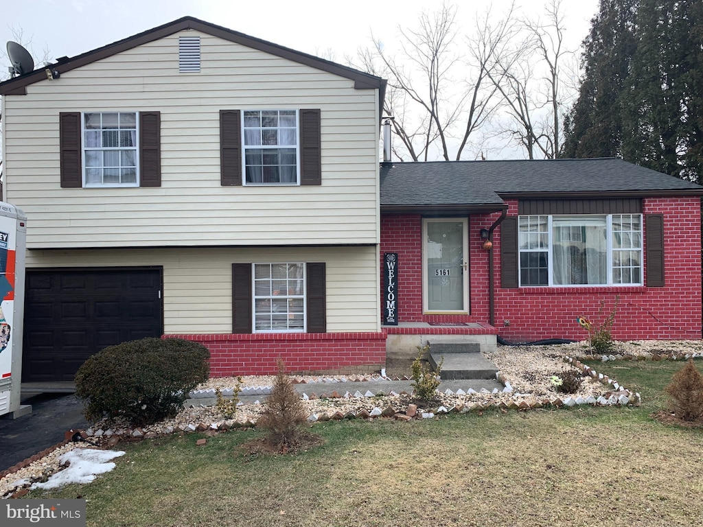 split level home featuring a garage and a front yard