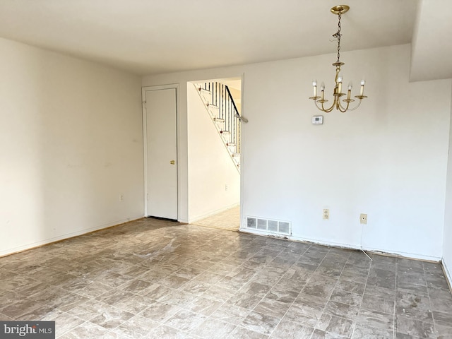 empty room featuring an inviting chandelier