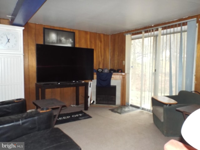 living room featuring wooden walls, carpet, and plenty of natural light