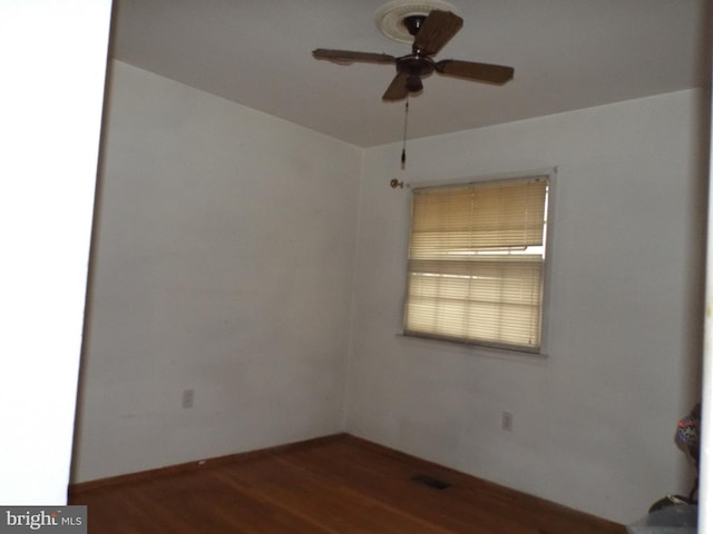 unfurnished room with dark wood-type flooring and ceiling fan