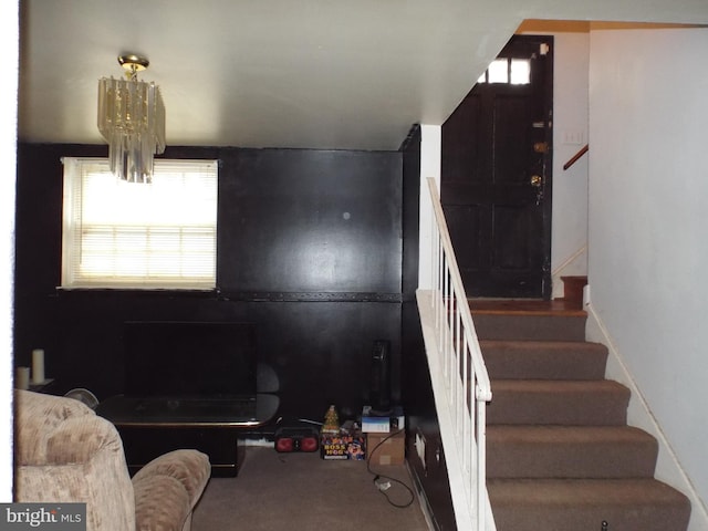 stairway featuring plenty of natural light, carpet floors, and a chandelier