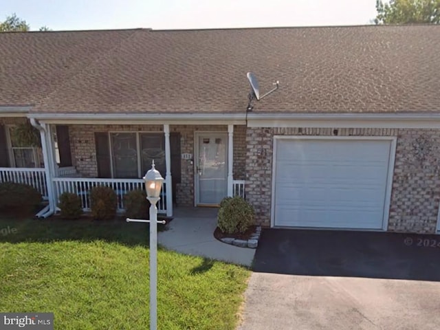 view of front facade with a garage, a front yard, and covered porch