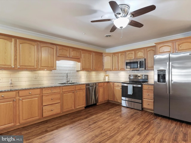 kitchen featuring sink, crown molding, appliances with stainless steel finishes, dark hardwood / wood-style floors, and light stone counters