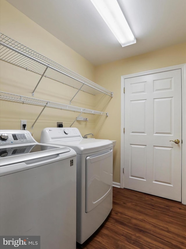 laundry area featuring dark wood-type flooring and washing machine and clothes dryer