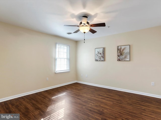 unfurnished room featuring dark wood-type flooring and ceiling fan