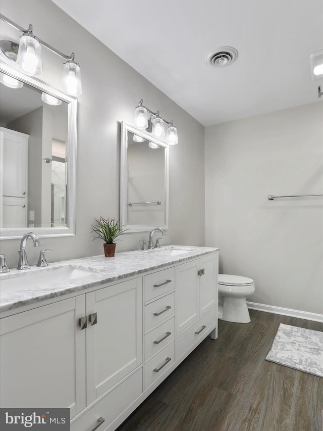 bathroom with hardwood / wood-style flooring, vanity, and toilet