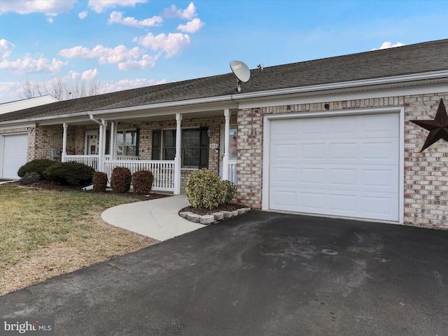 ranch-style home featuring a porch, a garage, and a front lawn