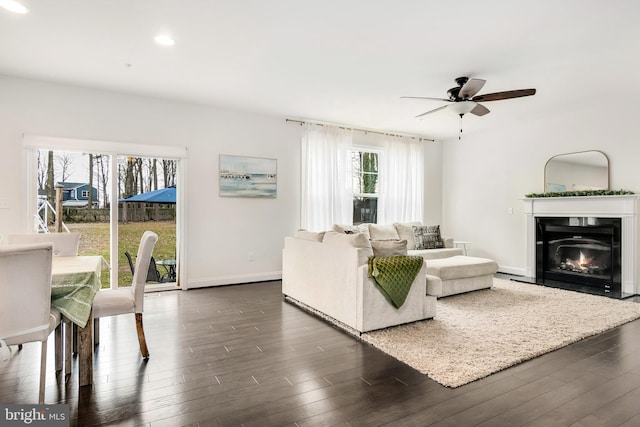 living room with dark hardwood / wood-style flooring and ceiling fan