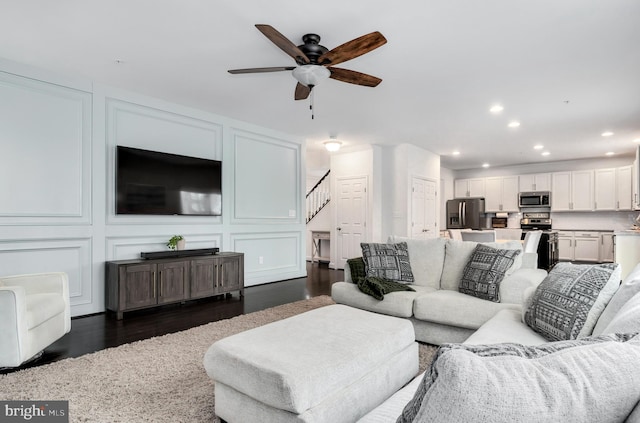 living room featuring ceiling fan and dark hardwood / wood-style flooring