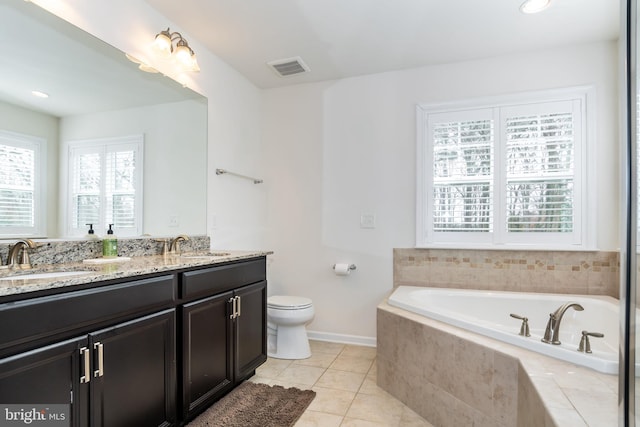 bathroom featuring vanity, toilet, tile patterned flooring, and tiled tub