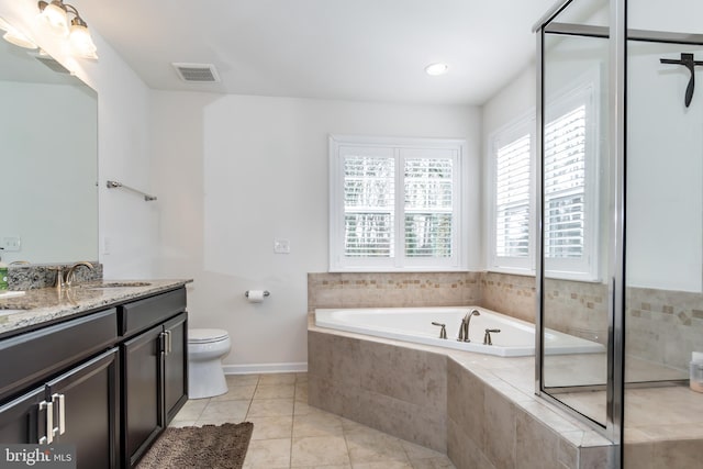 bathroom with vanity, a relaxing tiled tub, tile patterned floors, and toilet