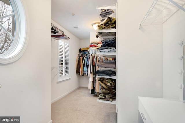 walk in closet featuring light carpet