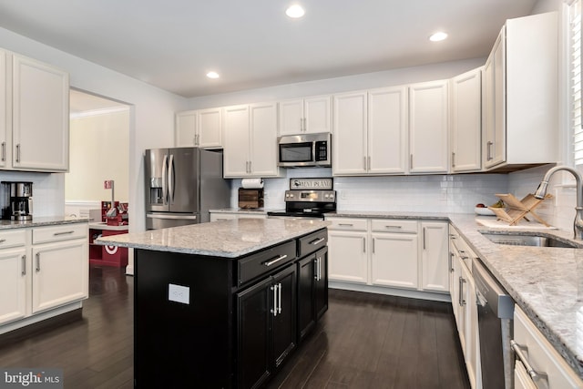 kitchen with sink, dark hardwood / wood-style floors, a kitchen island, stainless steel appliances, and white cabinets