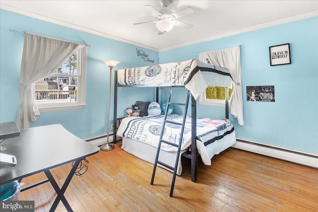 bedroom featuring multiple windows, crown molding, and wood-type flooring