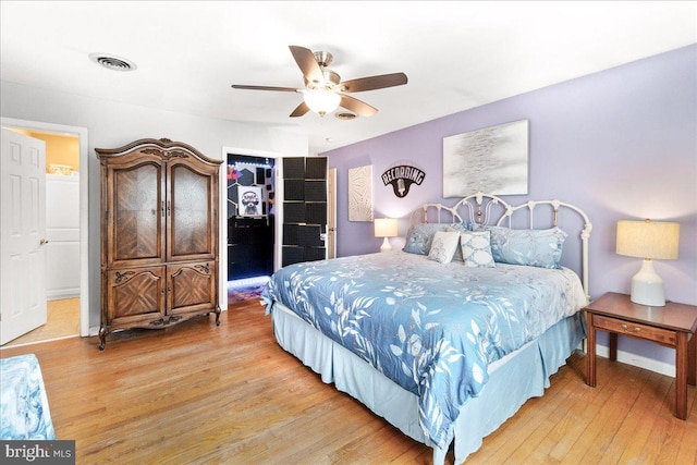 bedroom featuring a spacious closet, light hardwood / wood-style flooring, a closet, and ceiling fan