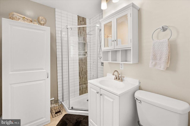 bathroom with vanity, a shower with door, and toilet