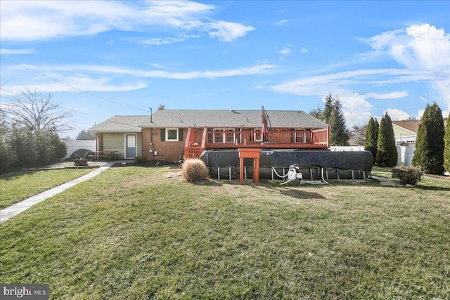 rear view of property featuring a lawn and a swimming pool side deck