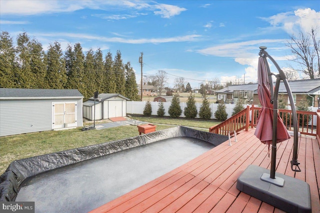 wooden terrace with a lawn and a storage shed