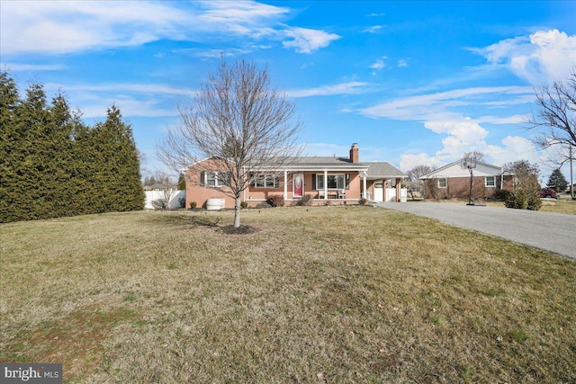 ranch-style home with a garage, a front yard, and a porch