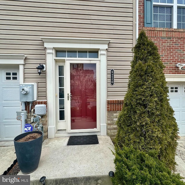 view of exterior entry with brick siding