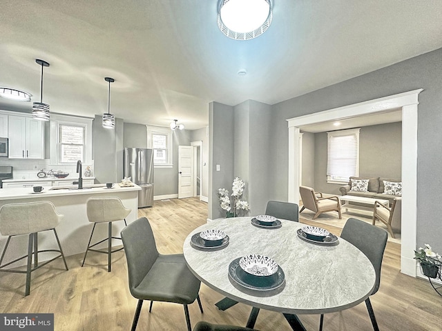 dining area with sink and light wood-type flooring