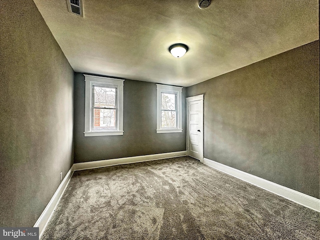 spare room featuring carpet and a textured ceiling