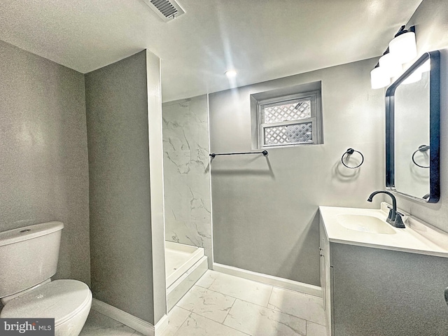 bathroom featuring vanity, toilet, and a shower